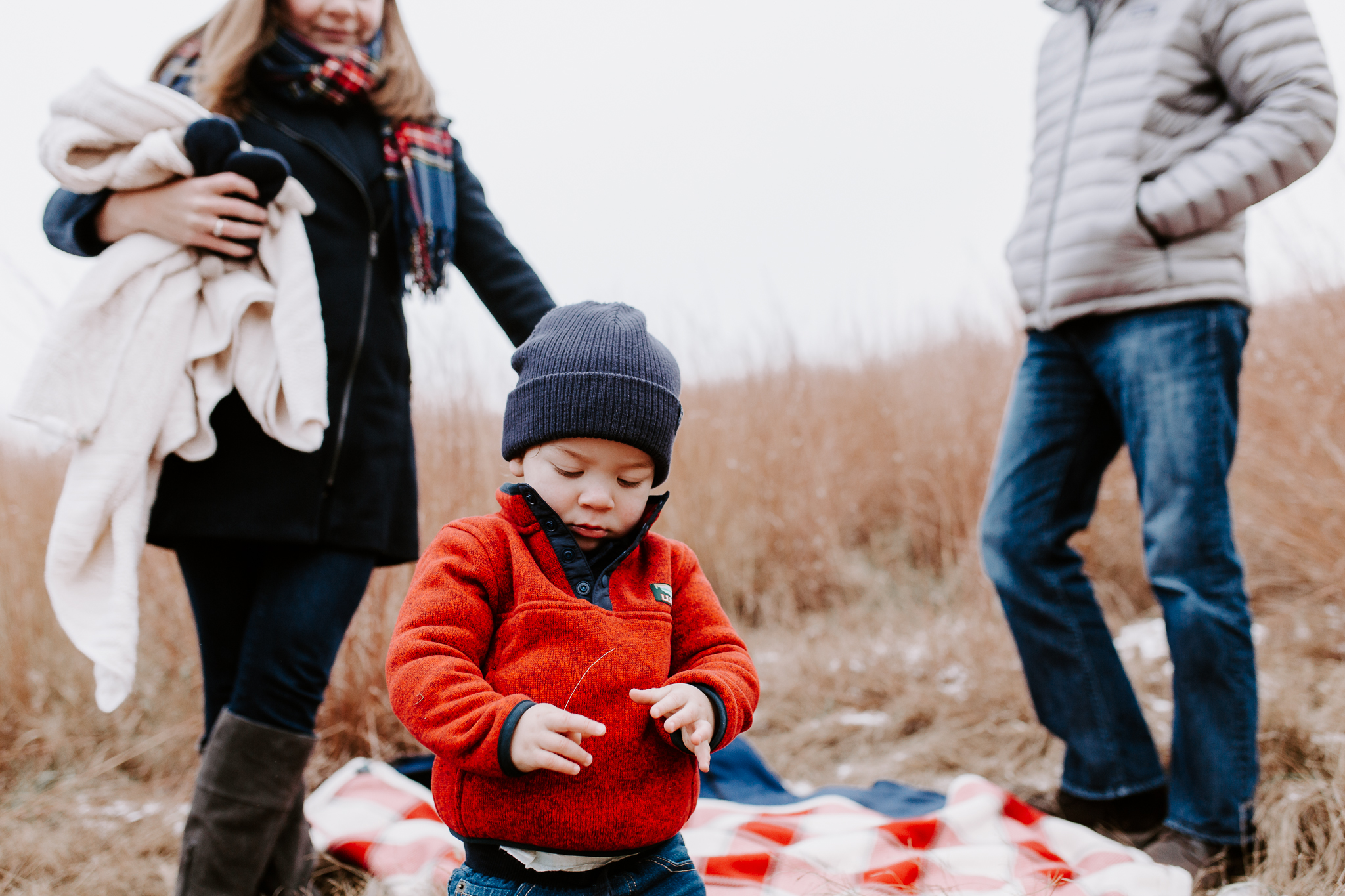 Young family lifestyle photo in a dried grass field with snow.